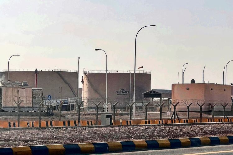 Große Treibstofftanks, darunter einer mit der Aufschrift „FIRE WATER 80,000 BBL“, stehen hinter einem Zaun in einem Depot in der Nähe des King Khalid International Airports in Riad. Laternenmasten und eine Sicherheitsbarriere sind im Vordergrund zu sehen.