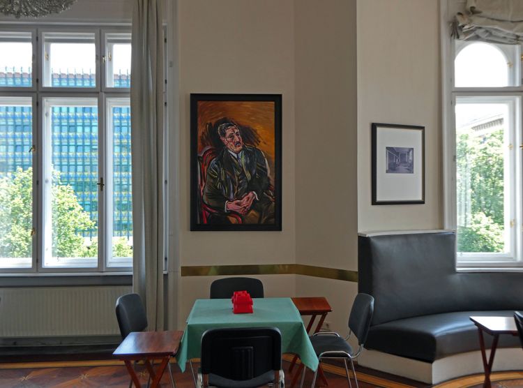 Wohnung mit einem Bild von einem Mann zwischen zwei Fenstern und einem Erker
