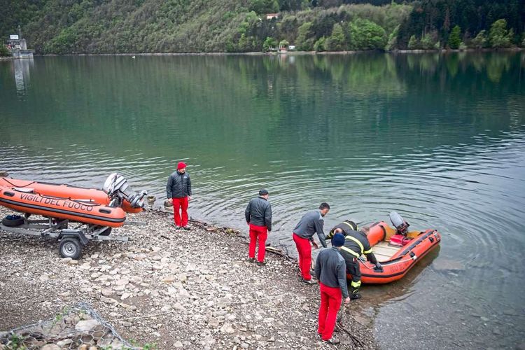 Schlauchbote und Rettungsarbeiter bei See Suviana auf Suche nach vermissten Arbeitern.