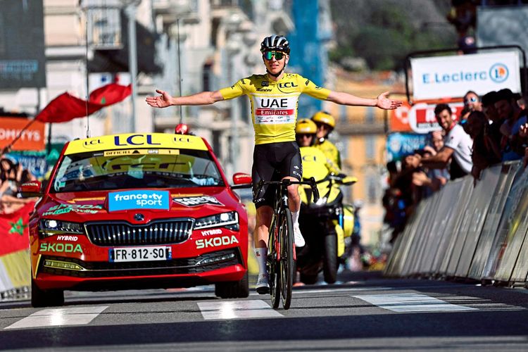 Tadej Pogacar rollt beim Etappenrennen Paris – Nizza mit ausgebreiteten Armen über die Ziellinie.