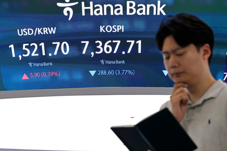 Ein Mann steht vor einem Finanzbildschirm im Handelssaal der Hana Bank in Seoul, Südkorea, am 8. Juli 2026. Der Bildschirm zeigt den Korea Composite Stock Price Index (KOSPI) bei 7.367,71 Punkten und den USD/KRW-Wechselkurs bei 1.521,70.