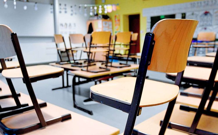 Stühle stehen auf Tischen in Klassenzimmer.