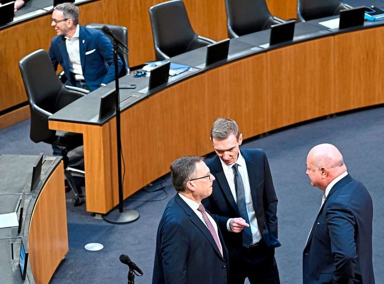 August Wöginger, Gunter Mayr und Christian Stocker stehen nebeneinander im Nationalratsplenum im Gespräch. Im Hintergrund sitzt Herbert Kickl an seinem Platz.