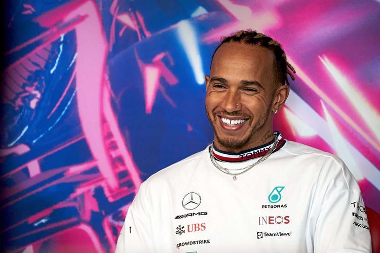 Lewis Hamilton lacht bei einer Pressekonferenz