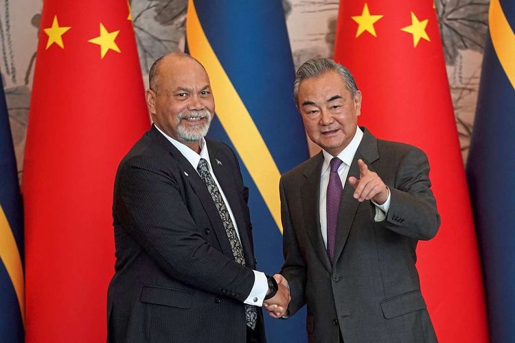 Chinas Außenminister Wang Yi und Naurus Außen- und Handelsminister Lionel Aingimea schütteln sich die Hände.