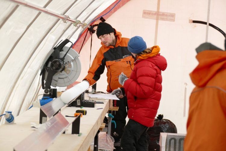 Forschungsteam in einem Zelt in der Antarktis beim Arbeiten mit Eisbohrkernen