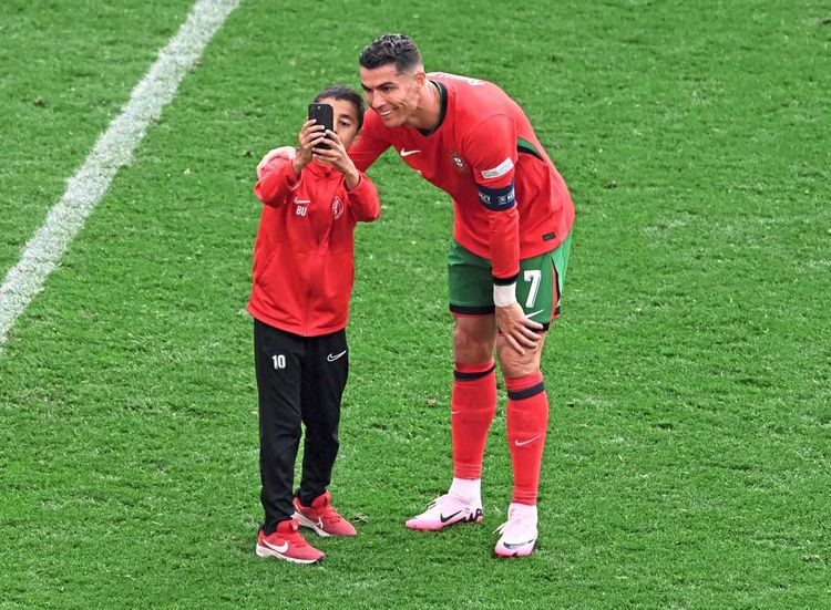 Kind fotografiert sich mit Ronaldo.
