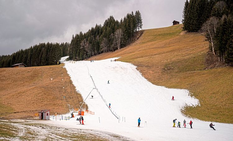 Blick auf ein als schmales weißes Band präparierte Skipiste in einem Skigebiet in Filzmoos.