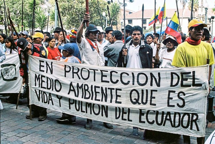 Eine Gruppe von Demonstrierenden, darunter indigene Awa in Ecuador, die ein Transparent mit der Aufschrift 