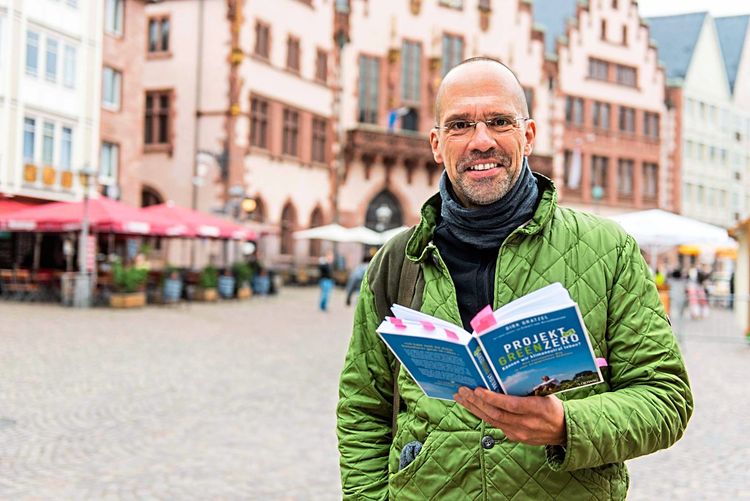 Dirk Gratzel mit einem Buch in der Hand