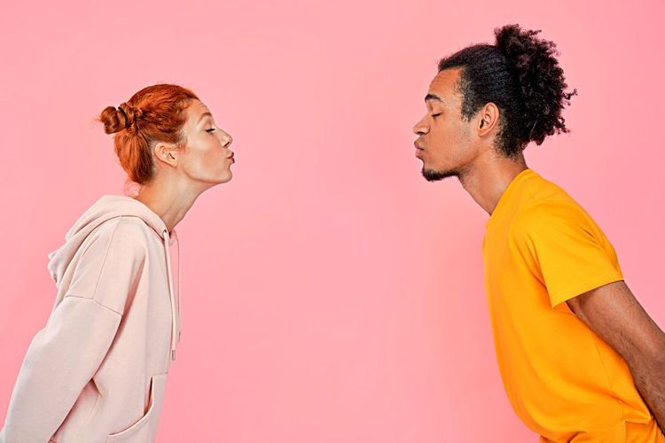 Zwei Jugendliche küssen sich, aber nicht auf den Mund, sondern im Abstand von einem Meter
