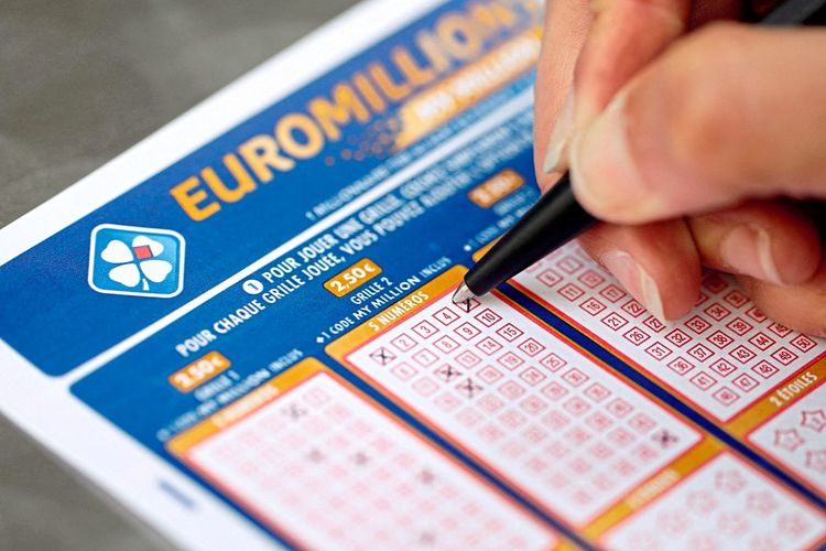 Hand füllt EuroMillionen Spielschein aus