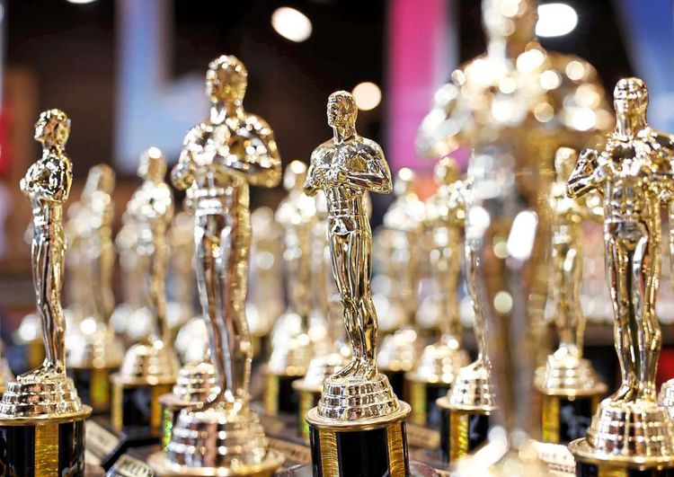 Nachbildung von Oscar-Statuetten auf einem Tisch.