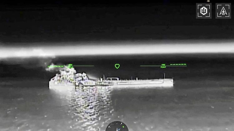 Schwarz-Weiß-Bild einer Wärmebildaufnahme, die ein Schiff zeigt, von dem Rauch und Feuer ausgehen. Es handelt sich um Drohnenaufnahmen, die durch grüne Markierungen und Symbole ergänzt sind. Das Schiff befindet sich auf einem Gewässer mit spiegelnder Oberfläche, vermutlich im Asowschen Meer.