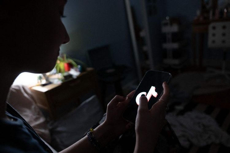 Junge Frau am Handy, dunkler Hintergrund