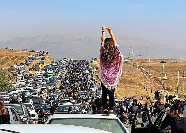 Proteste in Saqqez, Iranerin ohne Kopftuch auf Auto vor Menschenmassen