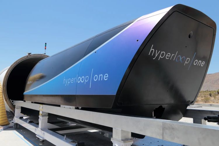 Das Bild zeigt eine Kapsel von Hyperloop One vor einem Röhreneingang