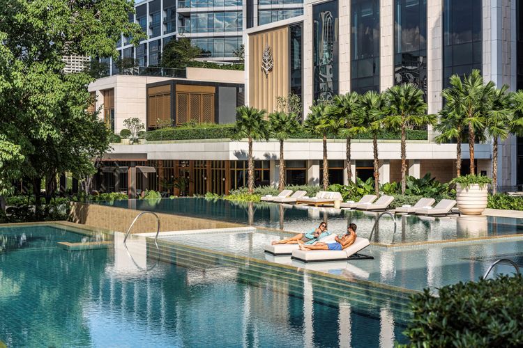 Hotel mit Poolanlage, zwei Personen auf Liegen