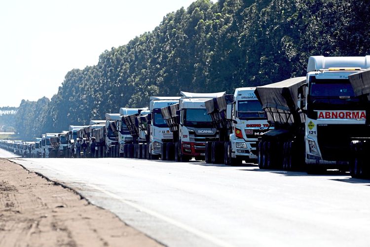 Auf einer Straße in Südafrika steht eine Reihe an Lastwagen befüllt mit Kohle.