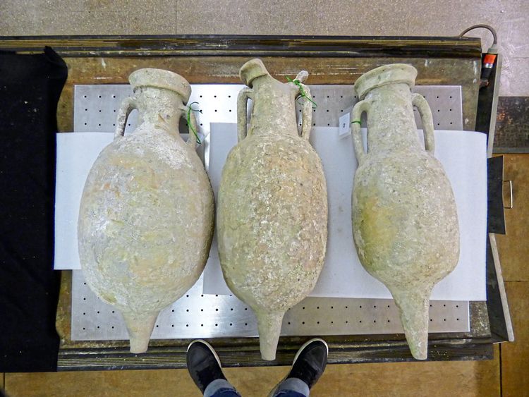 Drei gut erhaltene, bauchige Amphoren liegen auf dem Boden