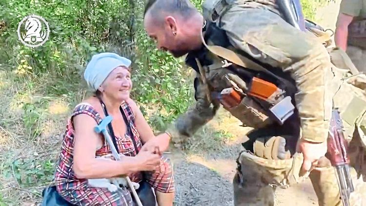 Ukrainischer Soldat grüßt Dorfbewohnerin von Robotyne.