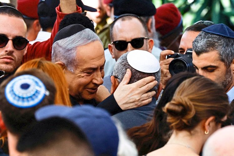Israelischer Premierminister Benjamin Netanjahu tröstet Gadi Eisenkot, einen israelischen Kabinettsminister und ehemaligen Militärchef, bei der Beerdigung von dessen Sohn Gal Meir Eisenkot, einem 25-jährigen israelischen Soldaten, der bei einer Bodenoperation im Gazastreifen getötet wurde. Die Beerdigung findet am 8. Dezember 2023 in Herzliya, Israel, statt. Umgeben sind sie von Trauernden, von denen einige Kippot tragen.