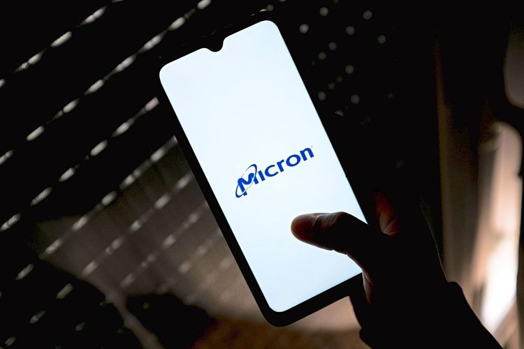 Eine Person hält ein Smartphone. Am Display ist das Logo des US-Chipherstellers Micron zu sehen.