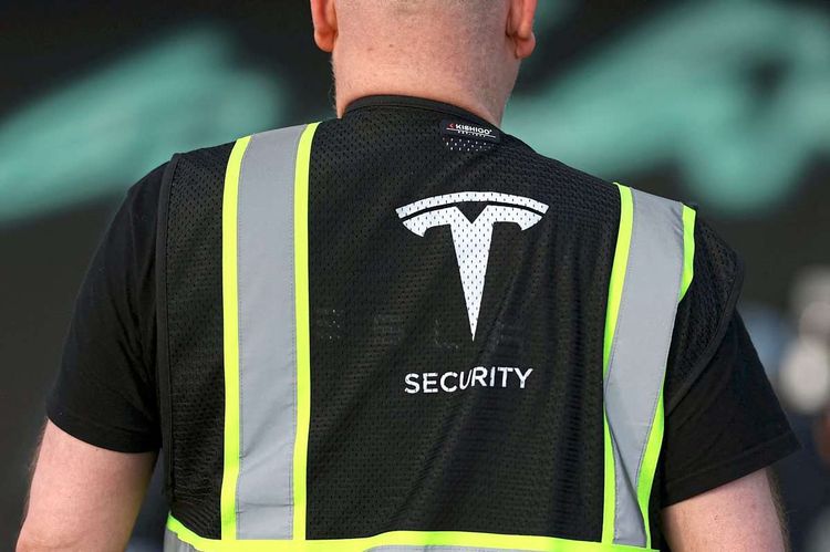 Mann in Warnweste mit Tesla-Logo