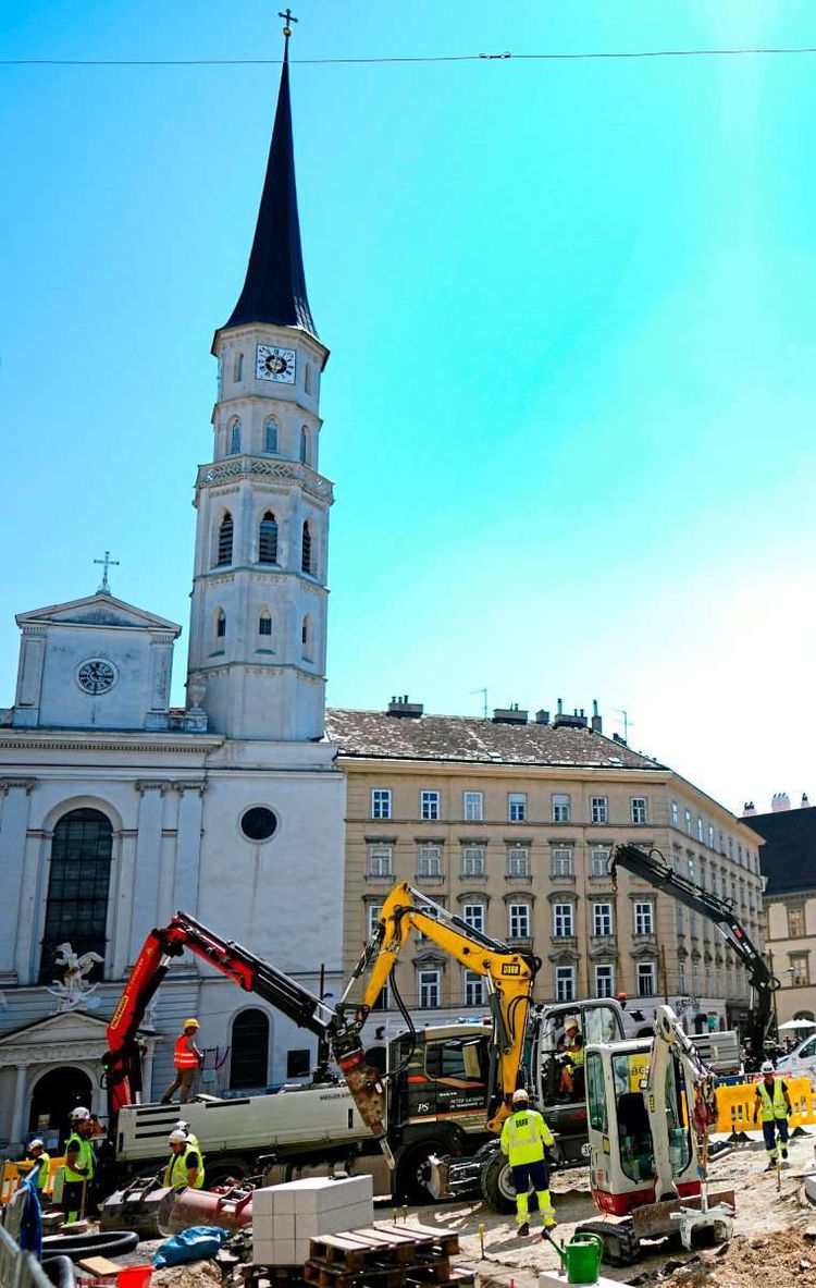 Bagger und Bauarbeiter am Michaelerplatz in der Wiener Innenstadt. Im Hintergrund ist die Michaelerkirche