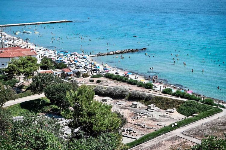 Der Strand von Kallithea auf Chalkidiki samt archäologischer Ausgrabung (Tempel des Ammon Zeus) im Vordergrund.