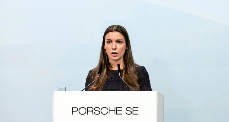 Eine Frau steht hinter einem Rednerpult mit der Aufschrift „Porsche SE“ und spricht.