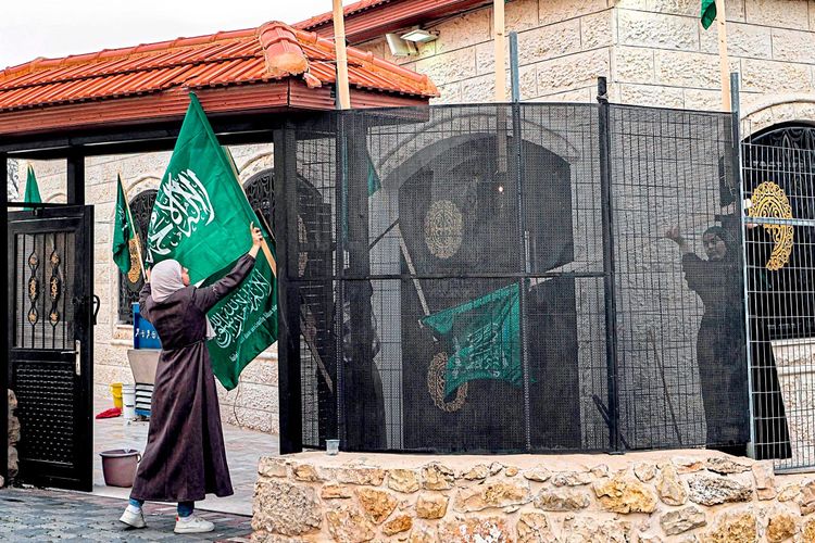 Verwandte von Saleh al-Arouri hängen Hamas-Flaggen in der Stadt Aroura nördlich von Ramallah auf.