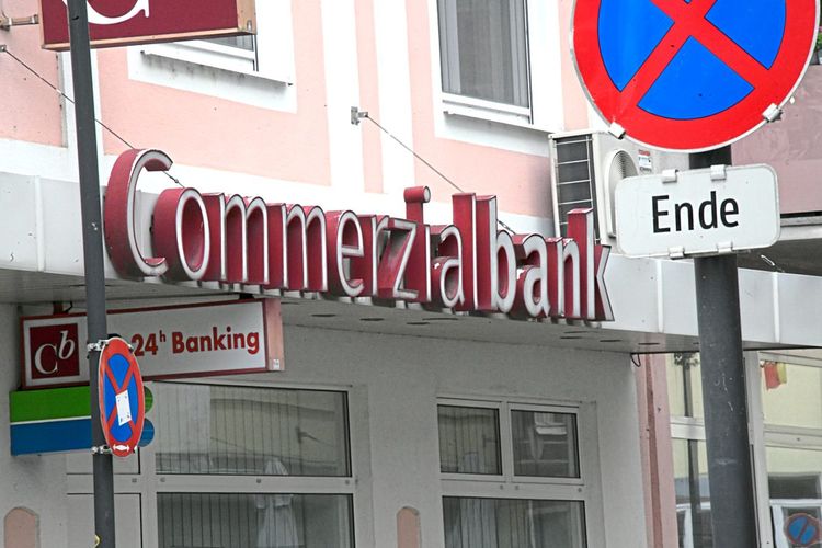 Eine Filiale der Commerzialbank in einem rosa Haus, davor ein Haltverbotsschild.