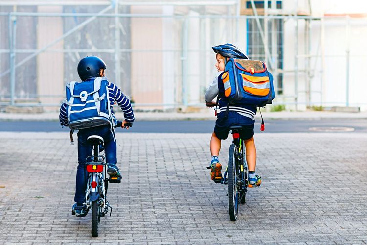 Zwei Kinder mit Helmen auf Fahrrädern
