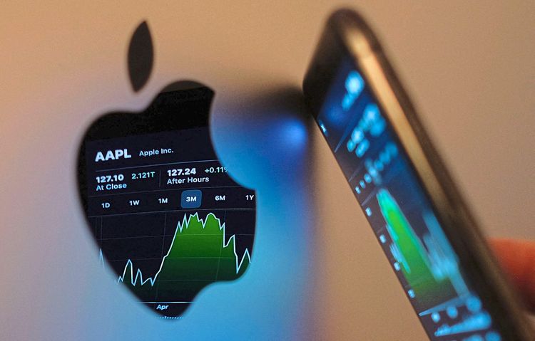 Eine Anzeige des Aktienkurses von Apple auf einem iPhone spiegelt sich in einem Apple-Logo