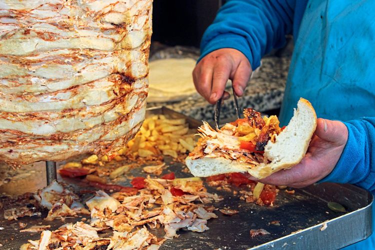 Ein Mann füllte Kebabfleisch in ein Fladenbrot