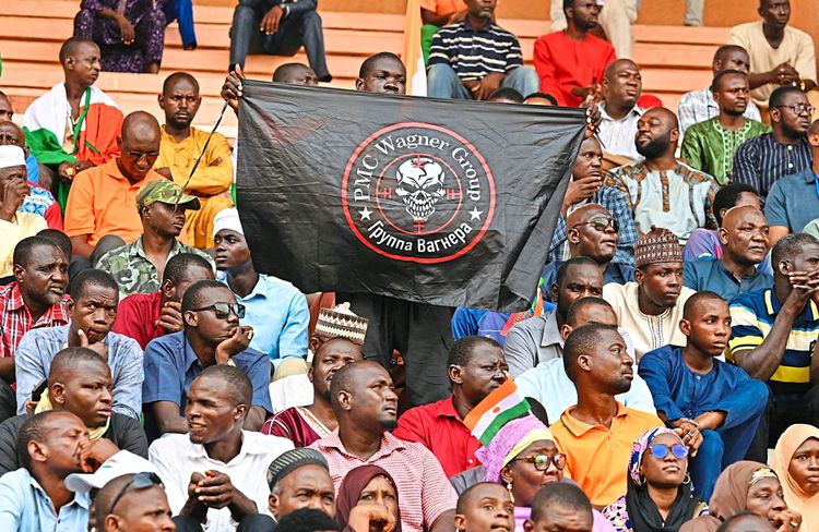 Ein Anhänger der neuen Militärjunta im Niger zeigt im Stadion von Niamey eine Fahne der Wagner-Truppe.