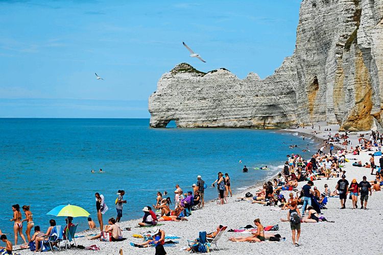 Strandbesucher an der Küste von Etretat im Nordwesten Frankreichs. Touristen bringen zwar viel Geld ins Land, schädigen aber auch die Umwelt.