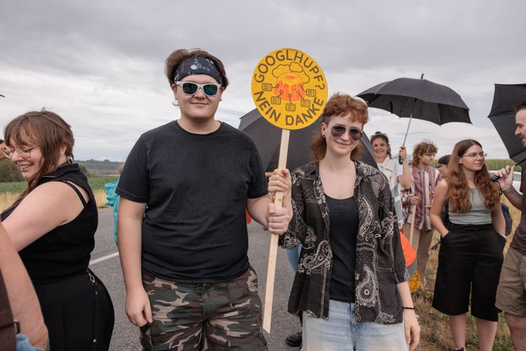Demonstrationsteilnehmende mit selbstgemalten Schildern. Eindrücke einer Demonstration gegen ein im Bau befindliches Google Rechenzentrum. Stallbach, Kronstorf, Oberösterreich, Österreich. 2026-07-17.