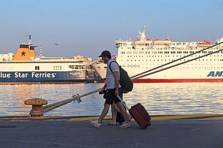 Touristen mit Rollkoffer vor Fähren nach Griechenland