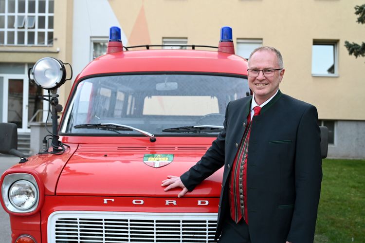 Alfred Strohmayer steht vor einem alten Feuerwehrauto