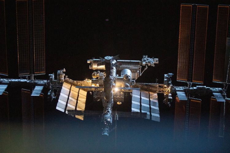 Die zentralen Teile der ISS, flankiert von den ausladenden Solarpaneelen, vor dem schwarzen Hintergurnd des Weltraums.