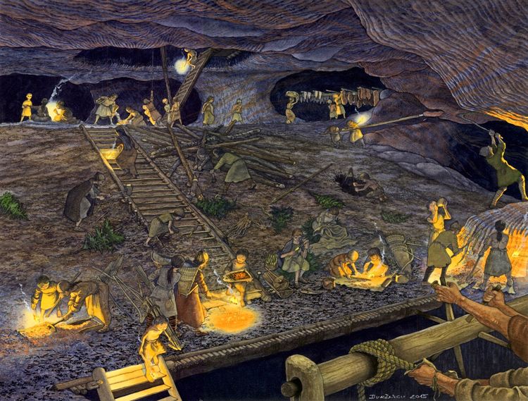 Illustration einer prähistorischen Szene in einer großen Höhle, in der Menschen bei der Arbeit dargestellt sind. Einige graben mit Werkzeugen in der Erde, andere transportieren Gegenstände oder arbeiten an Feuerstellen. Die Höhle ist mit Holzstrukturen, Stufen und Seilen ausgestattet, beleuchtet von Fackeln.