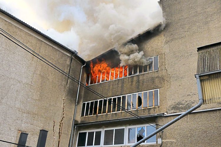 Flammen schlagen aus dem oberen Stock der Mühle
