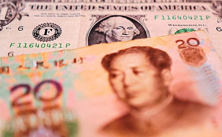 Ein Dollar-Schein und ein Yuan liegen übereinander.
