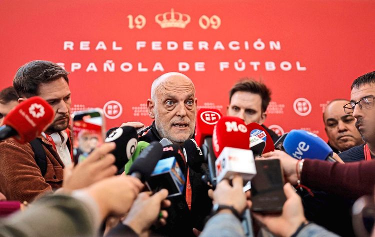 Eine Person spricht am 16. Dezember 2024 bei einer Medienveranstaltung in der Ciudad del Fútbol in Las Rozas, nahe Madrid, zu Journalisten. Im Hintergrund ist eine rote Wand mit dem Schriftzug „Real Federación Española de Fútbol“ und einem goldenen Krönungssymbol zu sehen. Mehrere Mikrofone unterschiedlicher Medien sind zu sehen.