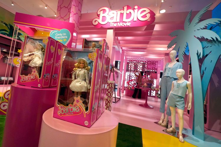 In einem Geschäft ist alles rosa dekoriert und Verpackungen mit Barbie-Puppen sind zu sehen.