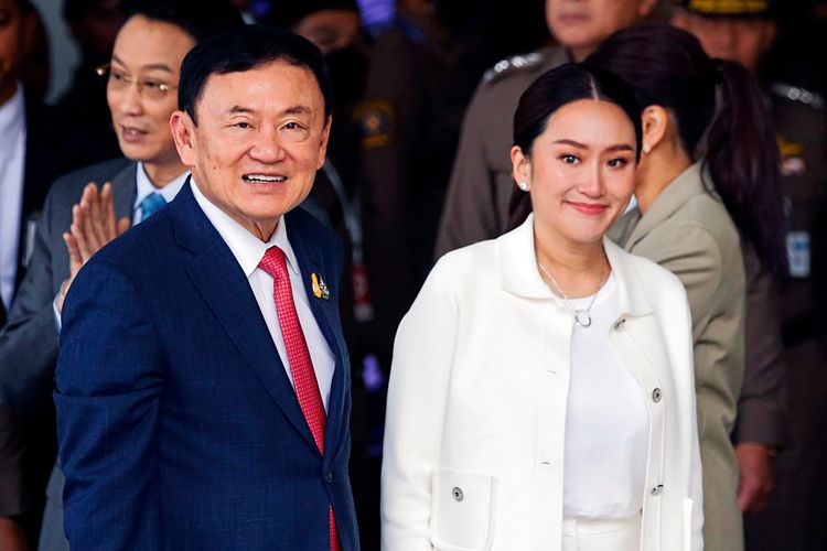 Thaksin im Anzug neben seiner Tochter im weißen Kostüm