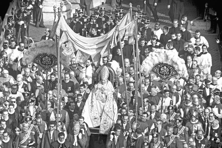 Der Papst wird auf einem Thron durch eine Menschenmenge getragen