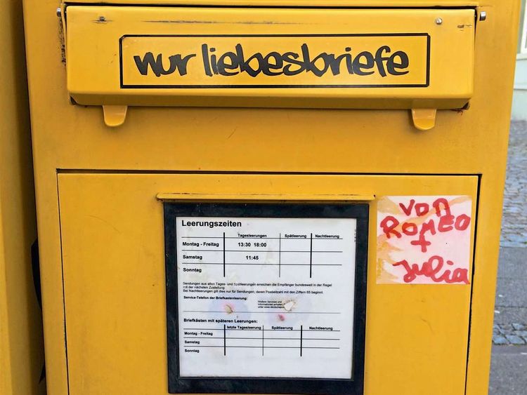 Auf einem gelben Postkasten steht in schwarzer Schrift 